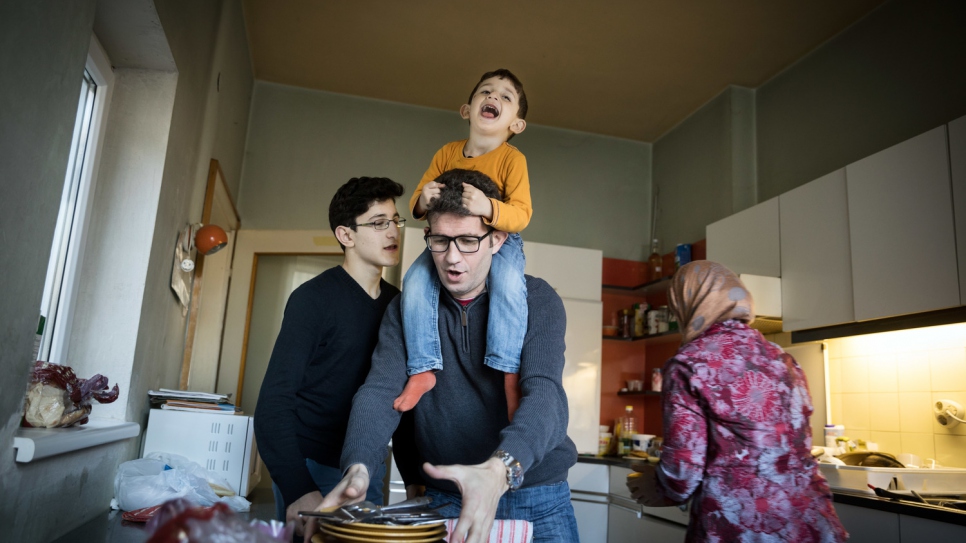 El pequeño Sohaib de tres años con su padre Ahmad en la cocina de su nueva casa en Mistelbach, Austria, donde viven con los dos primos de Sohaib. Sus padres fueron asesinados en Siria.