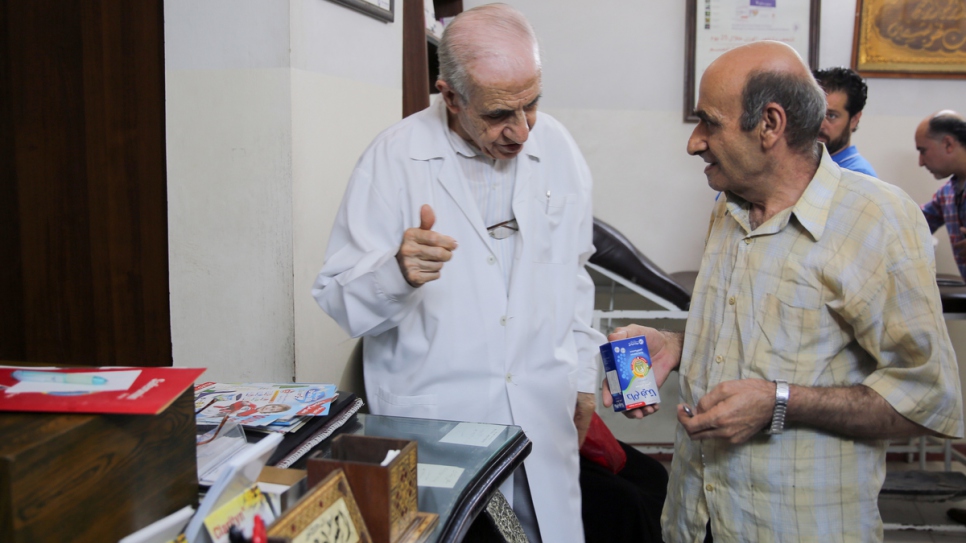 Dr Ihsan Ezedeen en discussion avec un patient à son dispensaire de Jaramana, près de Damas. En l'espace de sept ans, il aurait offert des soins médicaux à quelque 100 000 déplacés internes. 