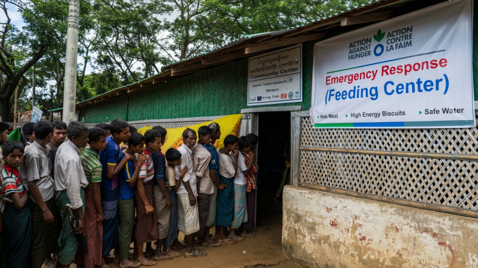 Refugiados rohinyá recién llegados hacen fila para recibir una comida preparada en el campamento de refugiados de Kutupalong, en Bangladesh.