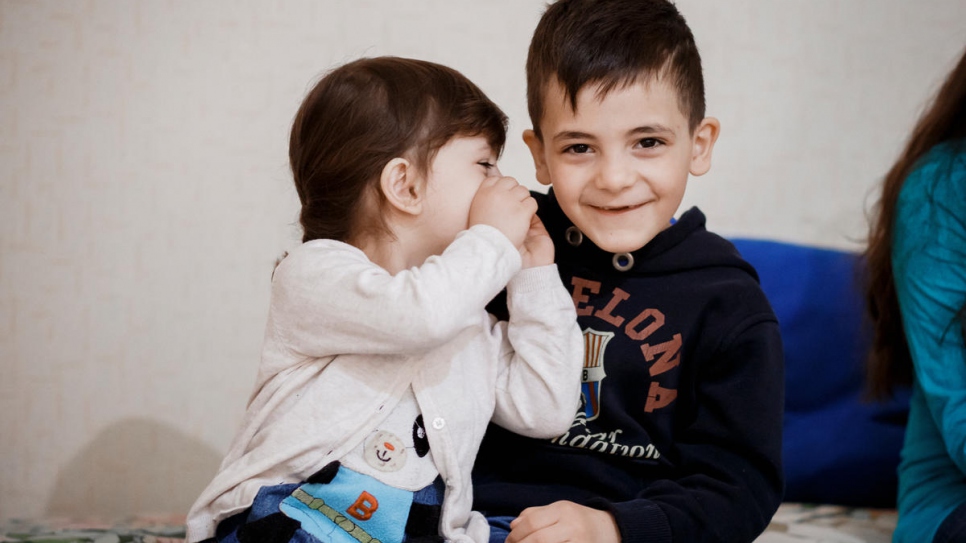 Aya Ahmad, deux ans, chuchote à l'oreille de son frère Rida, sept ans.