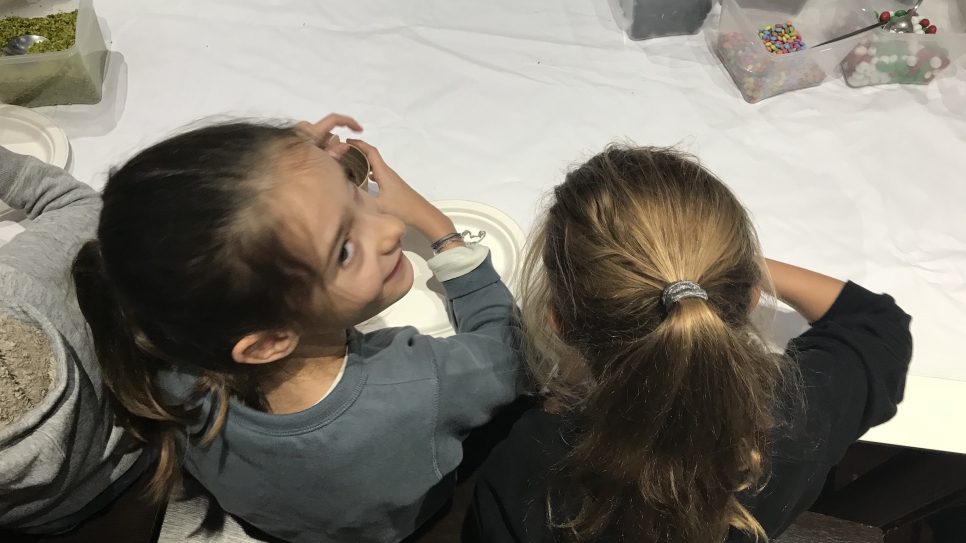 Deux petites filles participent à l'atelier cuisine du chef syrien réfugié, Mohammad Elkhaldy, lors de la collecte de jouets solidaire au Musée du Quai Branly à Paris le 27 décembre."Je leur raconte que c'est le moment le plus difficile qu'ait traversé la Syrie," raconte le chef aux enfants, afin de les sensibiliser à la situation.
