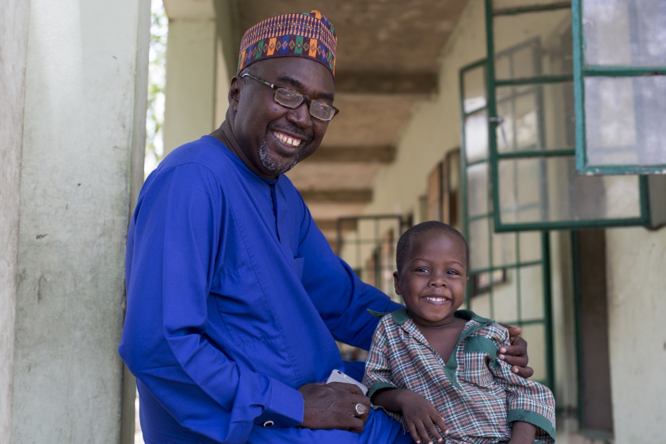 السيد مصطفى مع ابنه المسجل في حضانة المدرسة. مدرسة "مؤسسة براعة المستقبل الإسلامية" (I) في مايدوغوري، ولاية بورنو في نيجيريا
