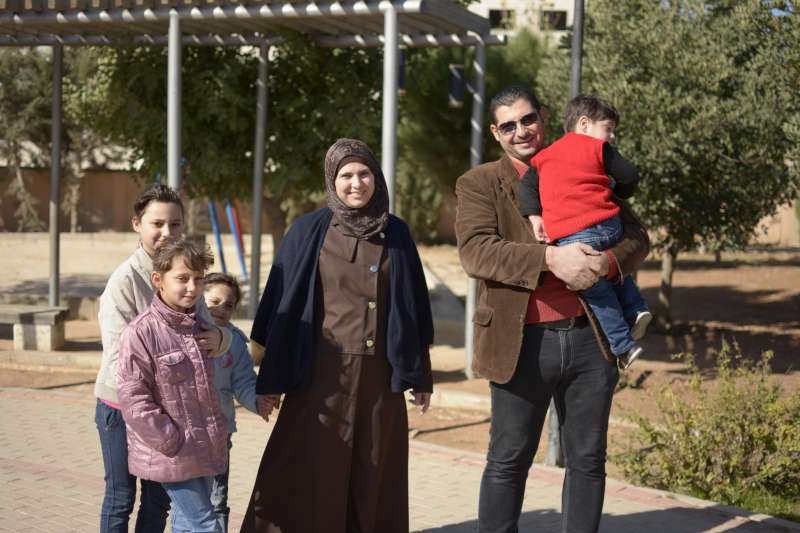 الطاهي السوري محمود وزوجته رشا يتصوران مع أولادهما الأربعة في منتزه محلي في العاصمة الأردنية عمان.