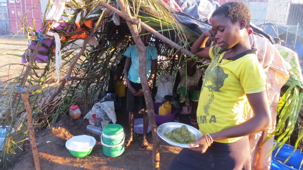  ابنة القائد كازينزي كاموينزا تحمل طبقاً من الخضروات المطبوخة المقدّم إلى العائلة من قبل أحد الجيران المتعاطفين قبل بدء عملية توزيع الطعام التي تنفذها المفوضية. 