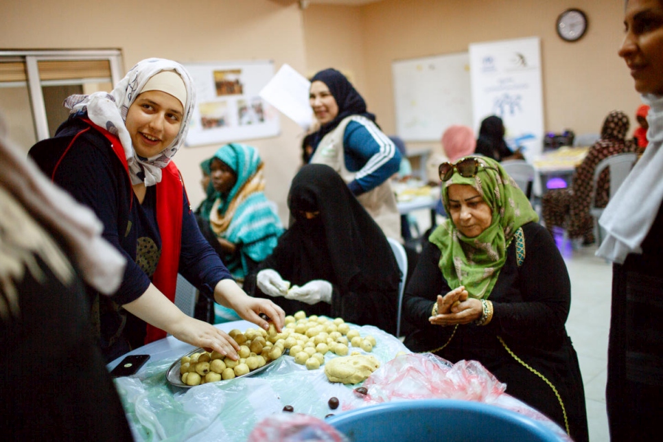 مجموعة من النساء اللاجئات من العراق واليمن وسوريا والسودان، بالإضافة إلى مواطنات أردنيات، يصنعن المعمول، لتوزيعه على الأسر المحتاجة اللاجئة والأردنية، في عمان، الأردن.