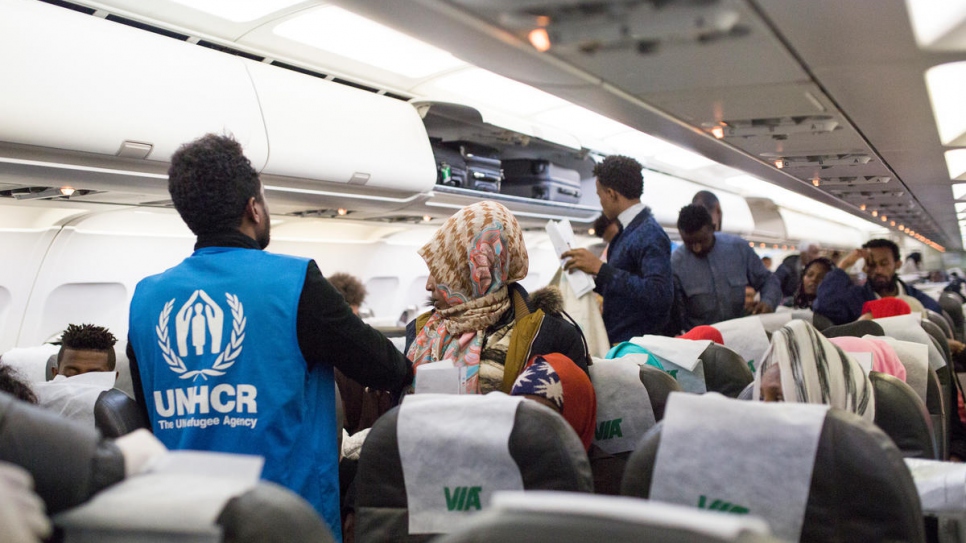 Le personnel du HCR fournit de l'aide aux réfugiés vulnérables à la descente de l'avion.