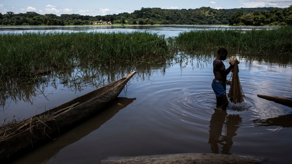 Un réfugié centrafricain nettoie son filet de pêche dans le village de Satema. 