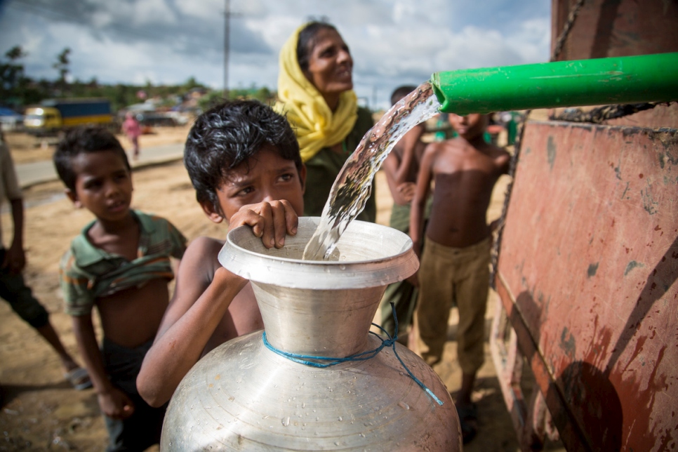 فتى روهينغي يملأ وعاء مياه من أنبوب في مخيم كوتوبالونغ للاجئين في بنغلاديش في 6 أكتوبر 2017.