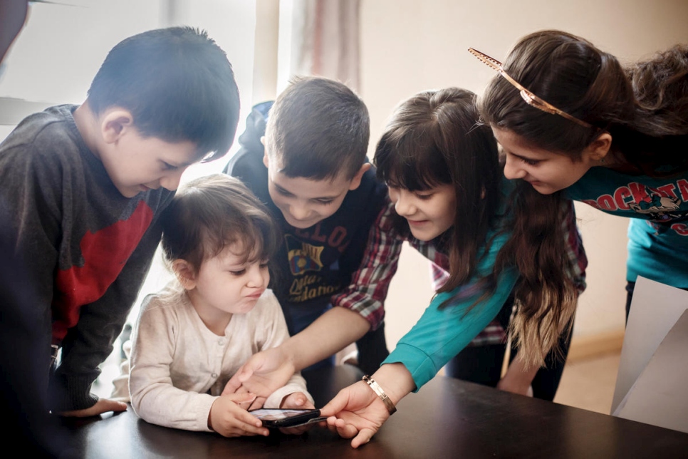 أطفال عائلة أحمد يلعبون معاً في منزلهم الجديد في غوميل، روسيا البيضاء.