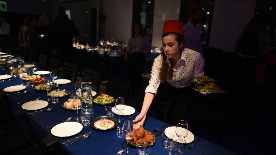 En prévision de la réception donnée après le défilé de mode de Kenzo, une serveuse dispose sur la table un assortiment de spécialités moyen-orientales préparées par Mohammad El Khaldy. 