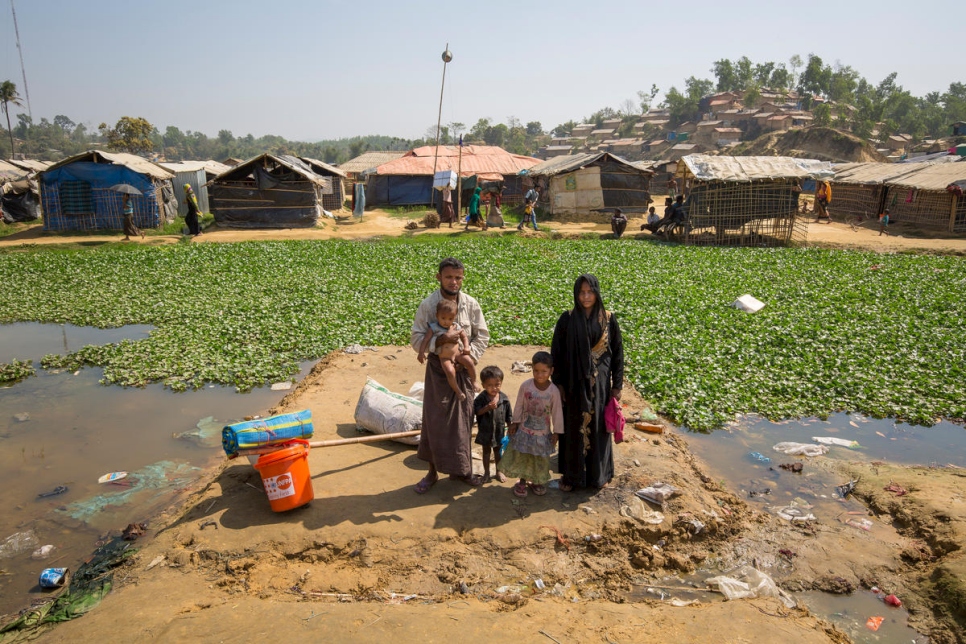 محمد حارس وزوجته مؤمنة بيغوم وأطفالهما في رقعتهم المعرضة للفيضان في مخيم كوتوبالونغ للاجئين، بنغلاديش، ينتظرون الانتقال إلى مأوى في منطقة أكثر ارتفاعاً.