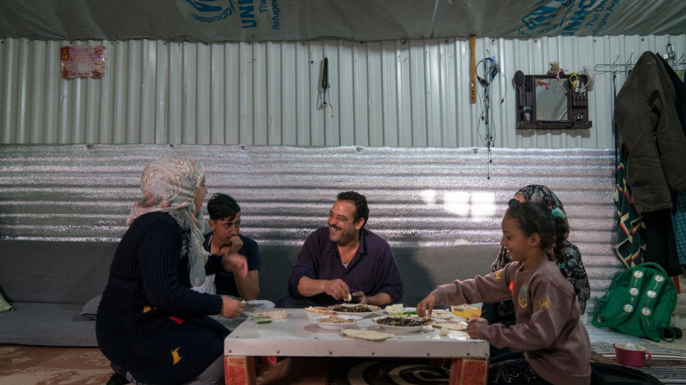 Ehsan Al Khalili, son épouse Rabab et trois de leurs enfants déjeunent dans leur abri, dans le camp de réfugiés d'Azraq, en Jordanie. 
