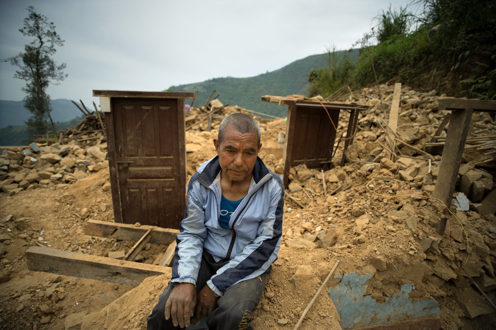 Dhan Bahadur Tamang sits amid the ruins of his home in Jhankridanda village, which collapsed during the earthquake last month in Nepal.