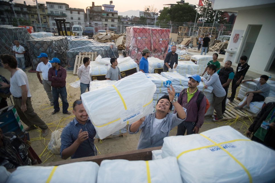 Volunteers working with UNHCR's local partners, including an organization known as Yellow House, load plastic tarps onto a truck to be distributed to affected communities across Nepal.