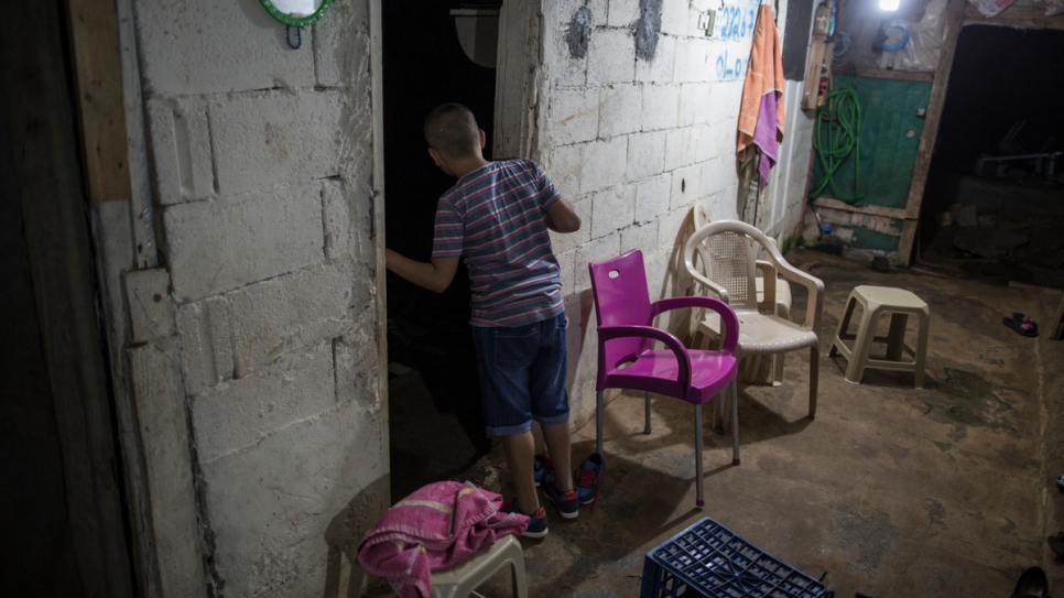 Mohamed Abdel, 10, looks in on his younger brother Issam, 8, asleep in his room at the family's temporary home in Jiyeh, Lebanon.