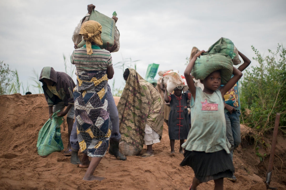 بعد تعبئة الرمل في أكياس من 25 كلغ، تحمله النساء والأطفال النازحون إلى مواقع البناء في كاليمي، عاصمة إقليم تنغانيكا، جمهورية الكونغو الديمقراطية.