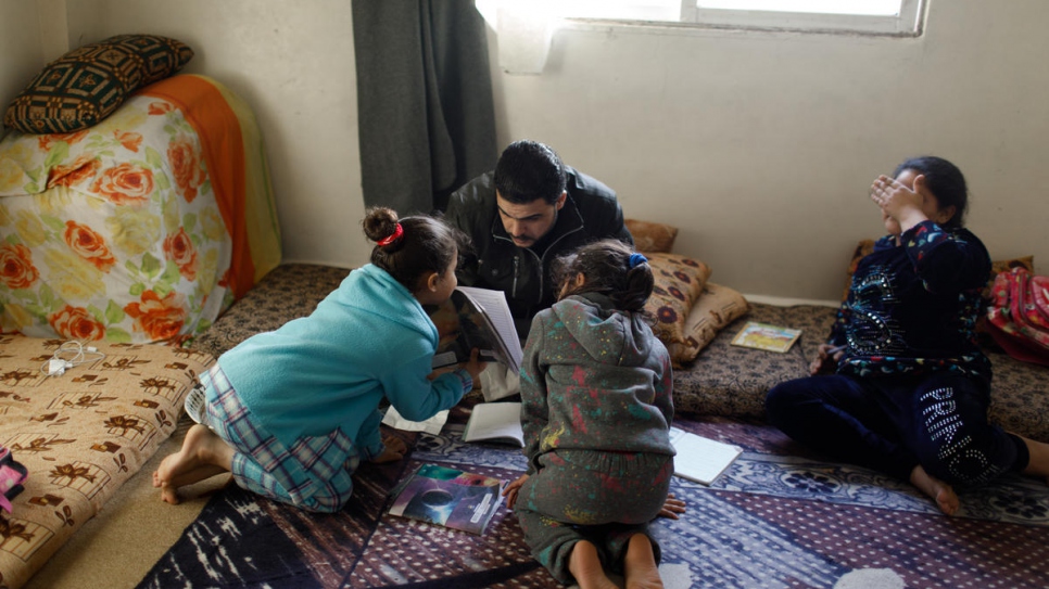 After his shift at the factory, 33-year-old Syrian refugee Mohammed Jamal Kabour helps his girls with their homework.
