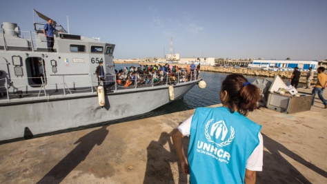 Une employée du HCR s'apprête à venir en aide, à Tripoli, aux réfugiés et aux migrants lors de leur débarquement. 