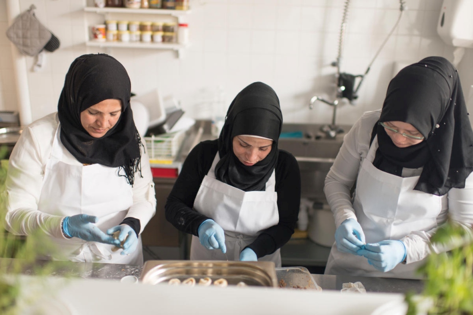 اللاجئات السوريات أقلام الخطيب وضياء أحمد وعبيق قاطرجي، يعملن في المطبخ الذي تديره رائدة الأعمال المولودة في سوريا، يارا الأديب.