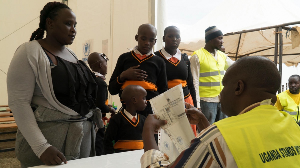 Jenipher, her daughter and a niece and nephew wait to be verified. 