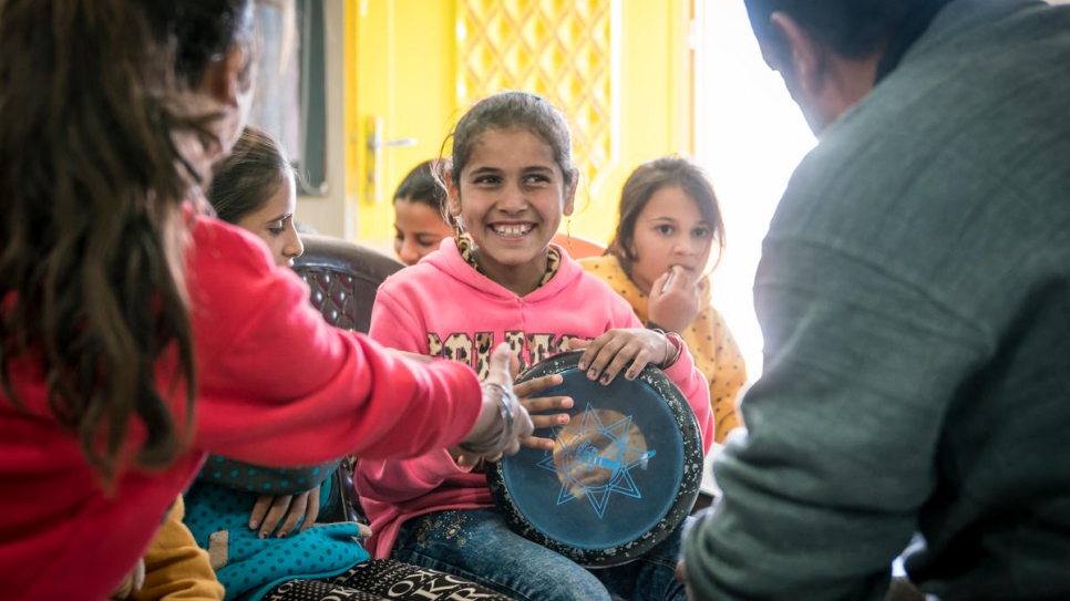 Syrian refugee Ehsan Al Khalili teaches music to a group of children in a UNHCR-funded community centre in Azraq refugee camp, Jordan.