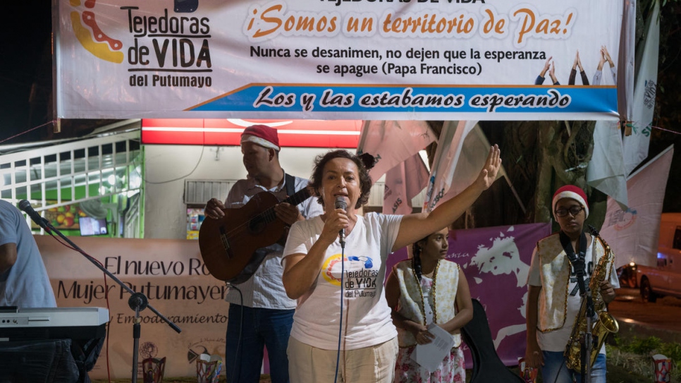 Fatima Muriel addresses the audience at a community event for "Dia de las Velitas" or "Little Candles Day", a traditional holiday in Colombia.