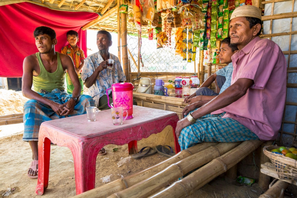 محمد إسلام (في الوسط) يشرب الشاي في كشك يديره كبير أحمد (يمين) وابنه نور محمد (يسار) في مخيم كوتوبالونغ للاجئين. 