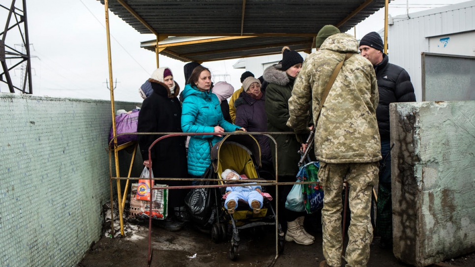 People wait to cross Mariinka checkpoint.