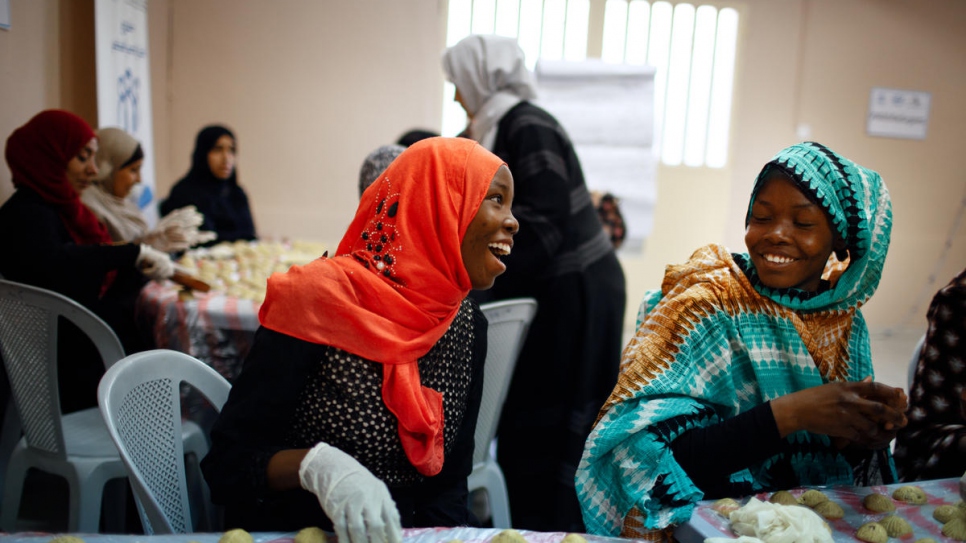 Deux soeurs réfugiées soudanaises Zainab Abdallah (à gauche en rouge) et Nuha (à droite) préparent des gâteaux arabes pour l'Aïd au Princess Basma Centre for Social Development à Amman, Jordanie. 