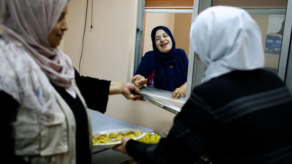Najwa Al Bedour (au centre), directrice du Princess Basma Centre for Social Development, discute avec des cuisinières réfugiées et jordaniennes qui préparent le 'ma'moul', à Amman, en Jordanie. 