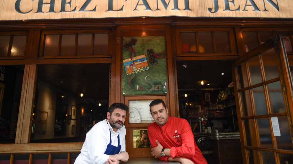 Le chef réfugié syrien Mohammad avec le chef du restaurant l'Ami Jean à Paris, en 2016. 