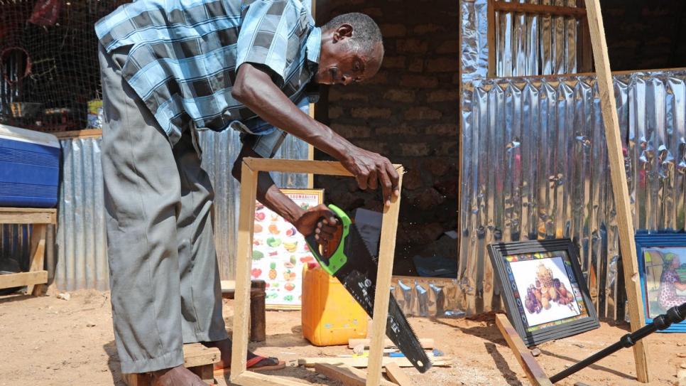 Mohamed fabrique un cadre en bois. 