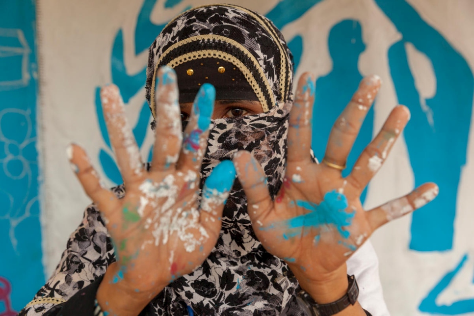 Une employée du HCR au Bangladesh, au centre de transit, s'est fait maquiller les mains du bleu de l'ONU.  