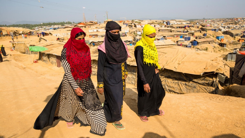Shamshidah, left, and Mabia, far right, walk to their shelter in Kutupalong refugee settlement, accompanied by refugee widow they met at the UNHCR information point.

