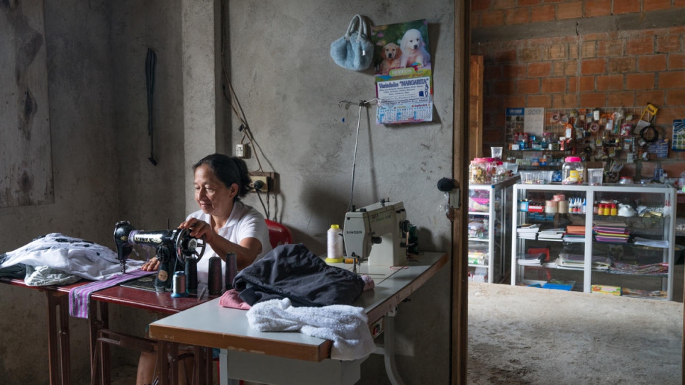 Alba Pinto works in her house in Nueva Esperanza. Since fleeing to the settlement she has saved and worked hard to open a shop here where she sells school supplies and other items.