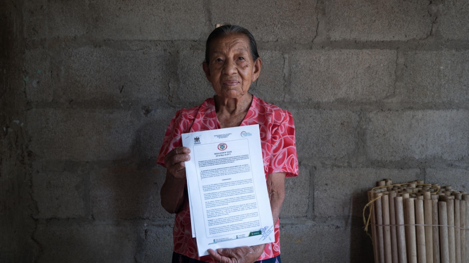 Blanca Elisa Pinto, 84, poses with the home title she received in August, 2017. After six years of lobbying, Nueva Esperanza became the first informal settlement to be legalized in Colombia's Putumayo region.