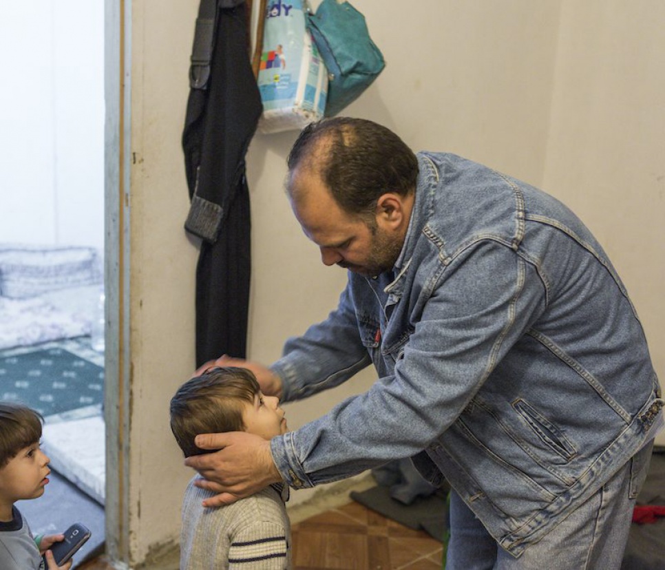 Omar's father, Khaled, brushes his hair before they go out. The family are looking forward to being resettled in Finland, where Omar can receive the treatment he desperately needs.