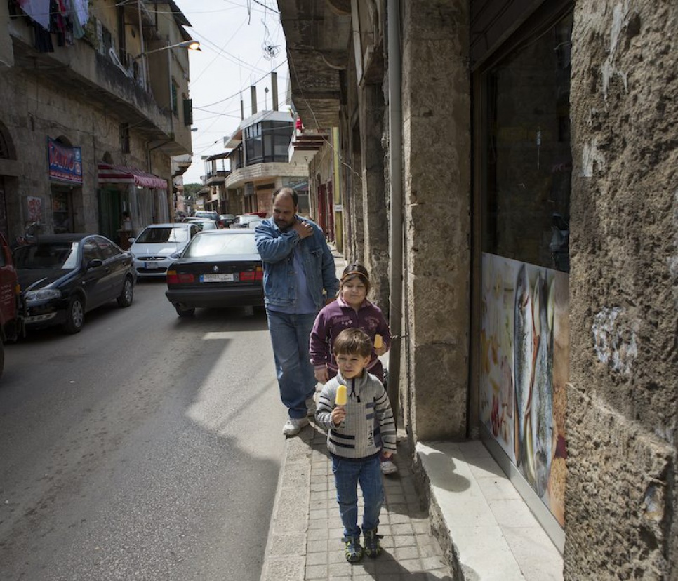 Omar walks home with his sister and father after playing football with friends.