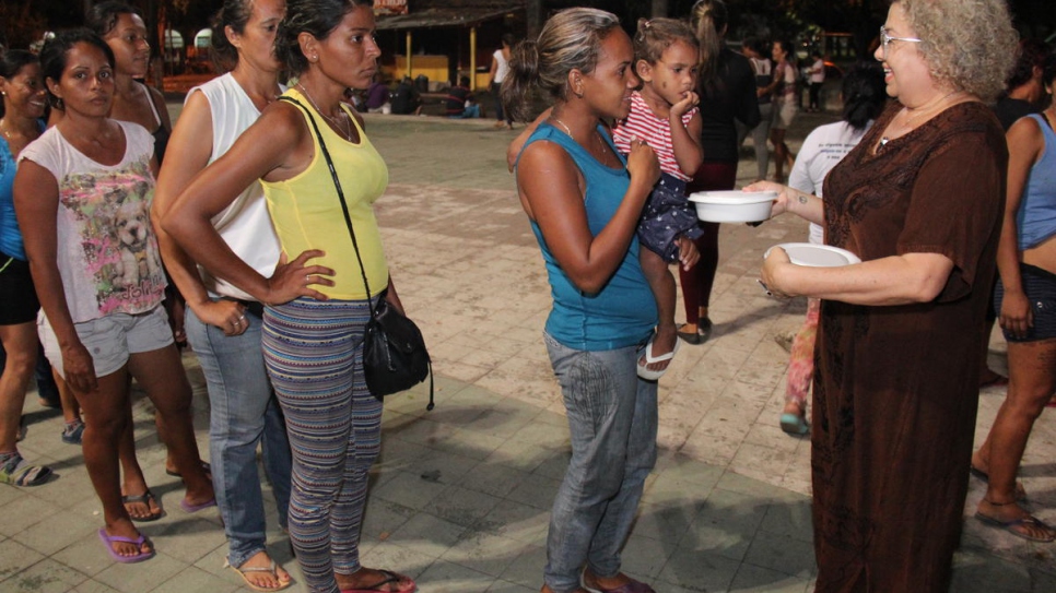 Ana Lucíola Franco (right) gives food donations to Venezuelans camped out in Simon Bolivar Square, Boa Vista, Brazil.