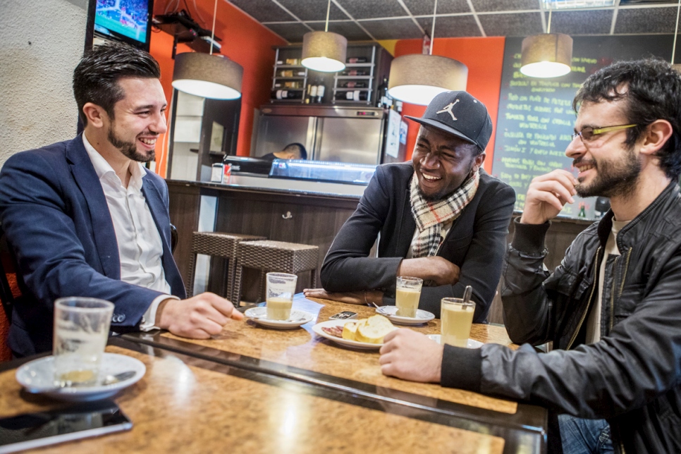 Spain. Asyum seeker and his two Spanish mentors meet for drinks