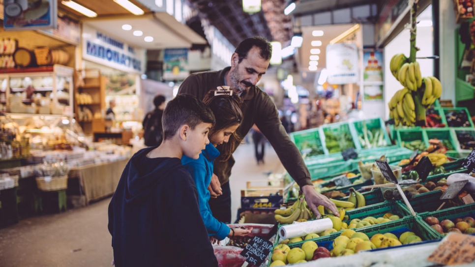 Ahmed shops for food with two of his children in the city of Chania, north-west Crete.