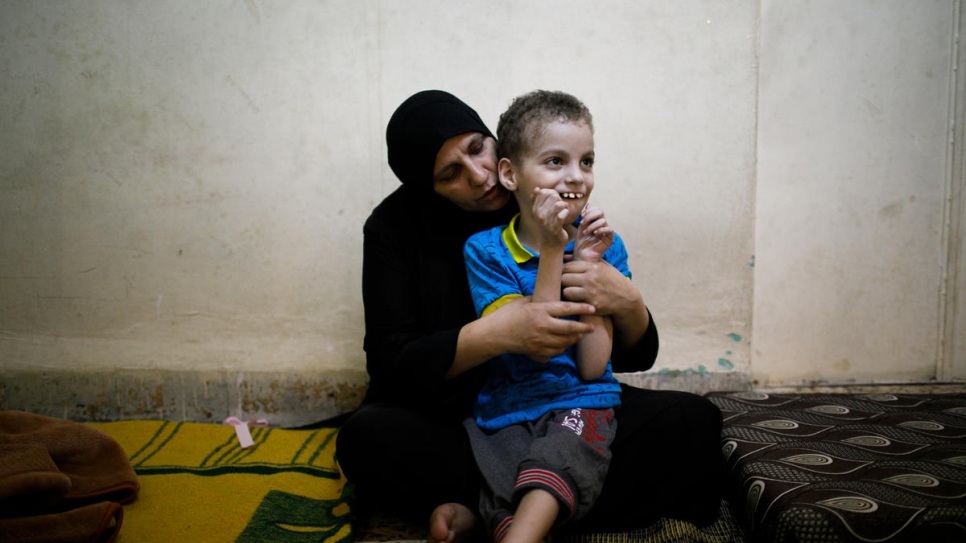Ghania Hamweh, une réfugiée syrienne originaire de Homs, joue avec son fils Abdul Hadi chez eux dans le camp de réfugiés urbains d'Al Hussain en Jordanie. Elle a reçu des confiseries fabriquées par des réfugiés et leurs hôtes jordaniens à Amman, en Jordanie. 
