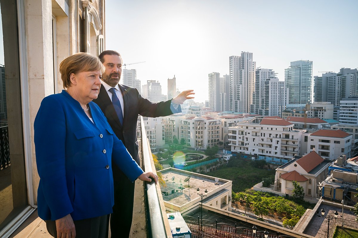 Ministerpräsident Hariri zeigt Bundeskanzlerin Merkel von einem Balkon aus die Stadt Beirut.