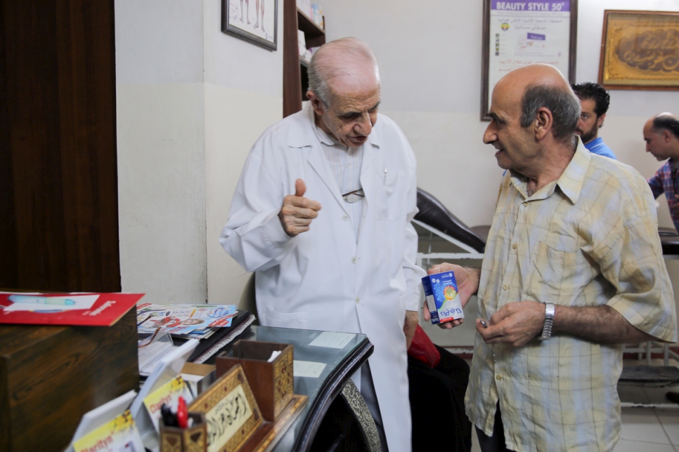 الدكتور إحسان عز الدين يتحدث إلى مريض في عيادته في مدينة جرمانا، بالقرب من دمشق. ويقدّر بأنه قدم على مدى سبع سنوات الرعاية الطبية إلى 100,000 من النازحين داخلياً.