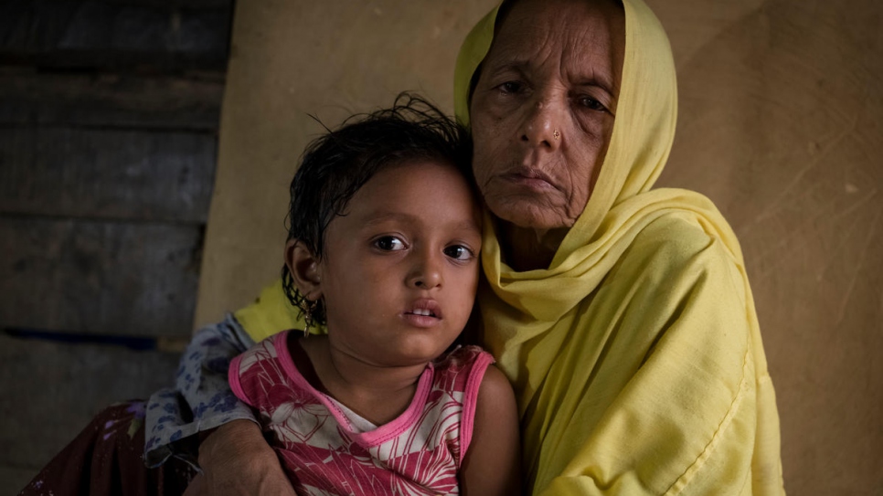 Mutaybatu, une réfugiée rohingya âgée de 55 ans, serre contre elle sa petite-fille adoptive dans un abri au sud-est du Bangladesh. Elle a fui le Myanmar en 2017. 
