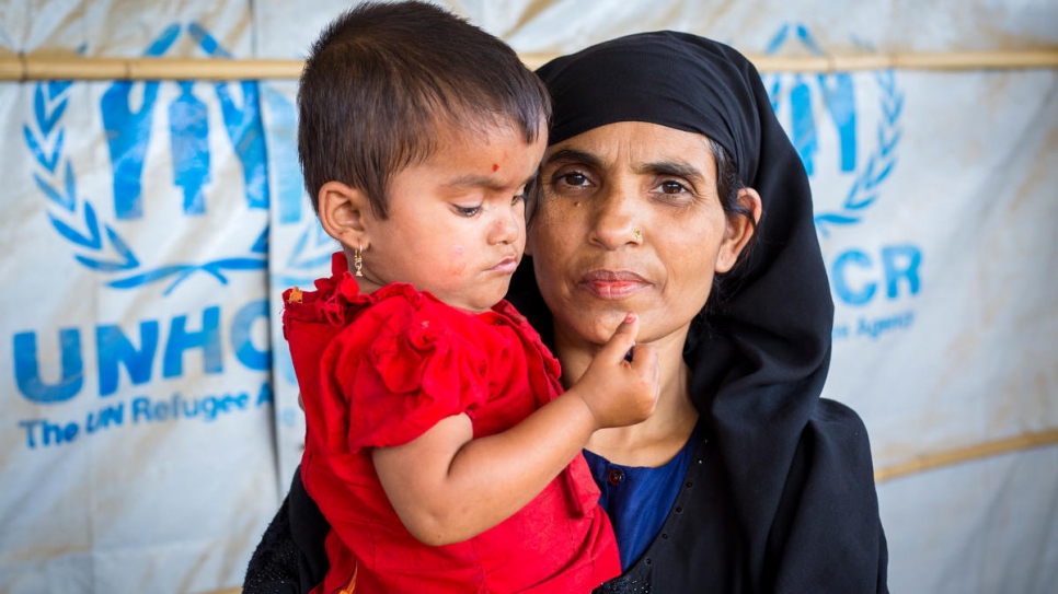 Khatemunnesa, âgée de 40 ans, porte sa fille dans ses bras, dans le centre d'information du HCR, au camp de réfugiés de Kutupalong, au Bangladesh. 