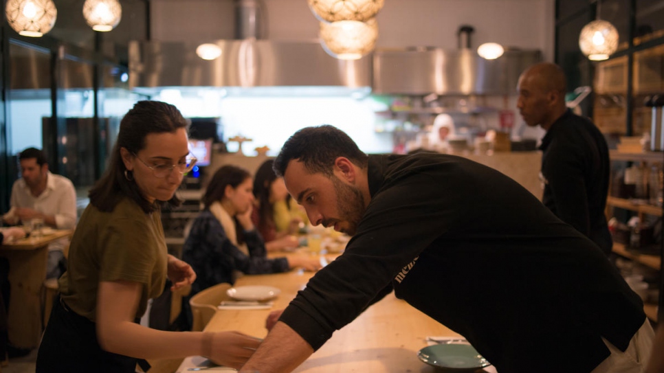 Rafat Dabah, un serveur d'origine syrienne, dresse la table au Mezze, le restaurant syrien de Lisbonne. Il a rejoint sa mère et ses deux soeurs au sein de l'équipe du Mezze. 