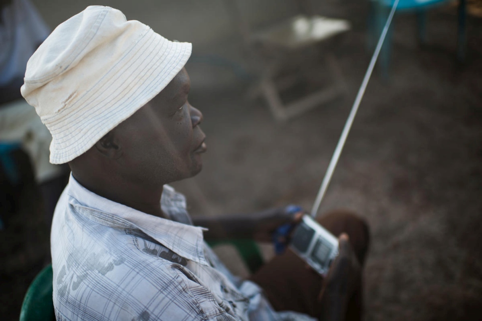 Peter Juma Maru, 66 ans, écoute la radio devant son abri. Il est contraint à vivre loin de sa famille du fait de la pénurie d'abris sur le site de Meri, en RDC. 