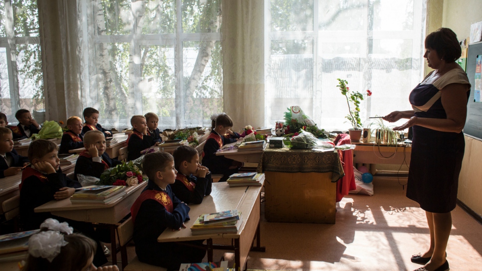 Les écoliers attentifs pendant leur première classe dans une école reconstruite de Louhansk. 