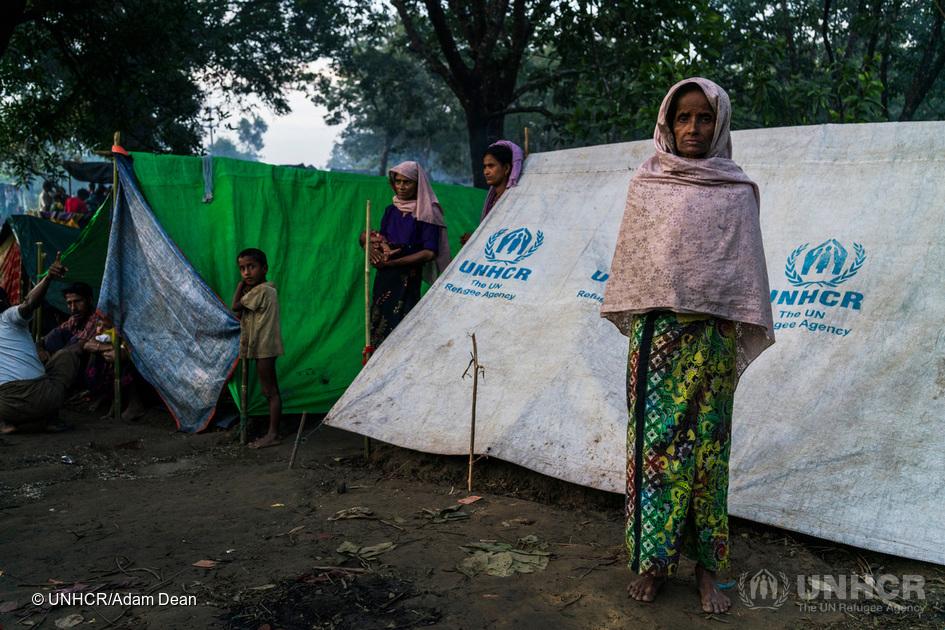En rohingyakvinna som flytt våldet i Myanmar står utanför sitt tält i en informell bosättning för nyanlända, nära Kutupalong-lägret i Bangladesh. © UNHCR / Adam Dean